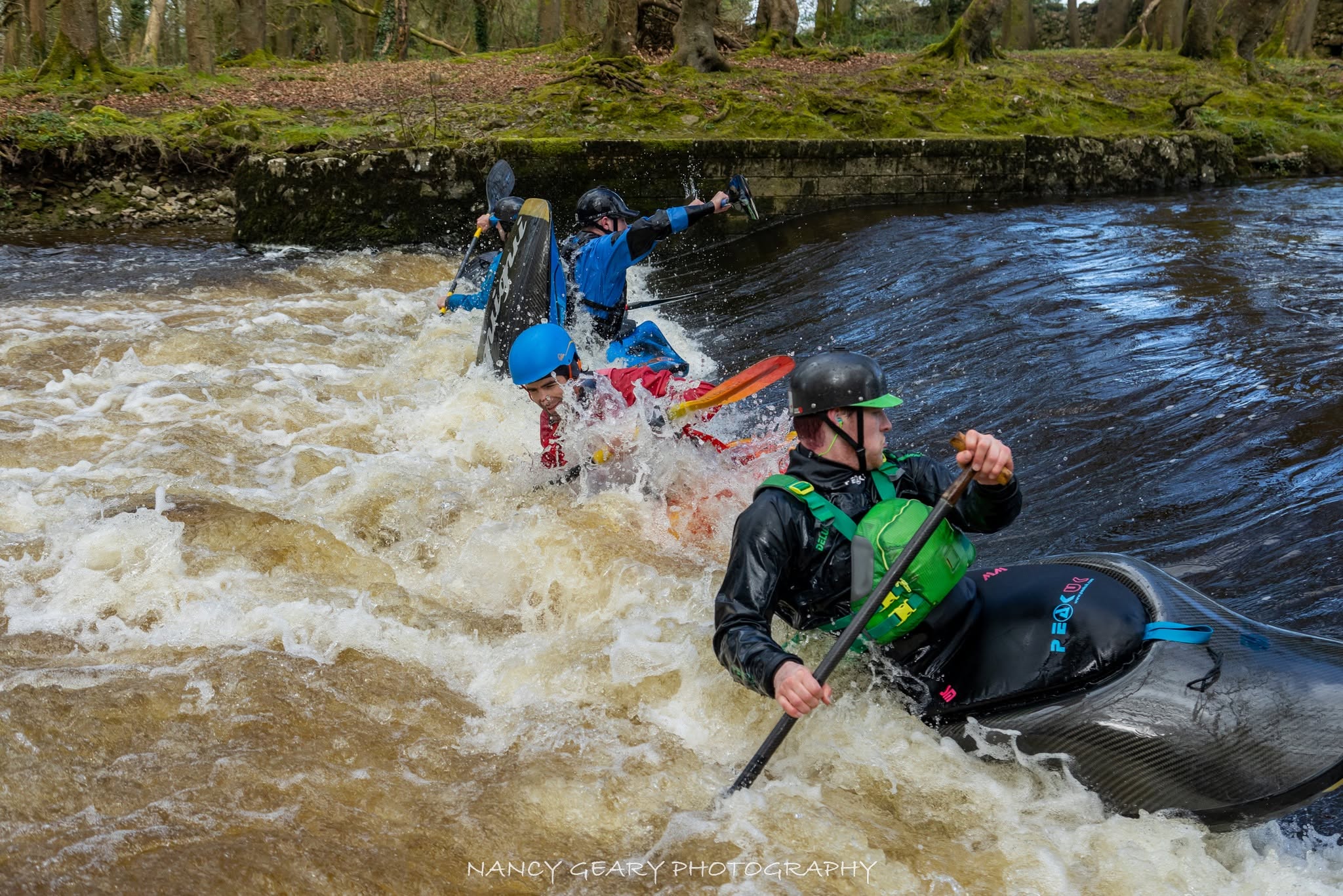 Freestyle paddlers surfing Tuam Wave on the River Clare in Ireland